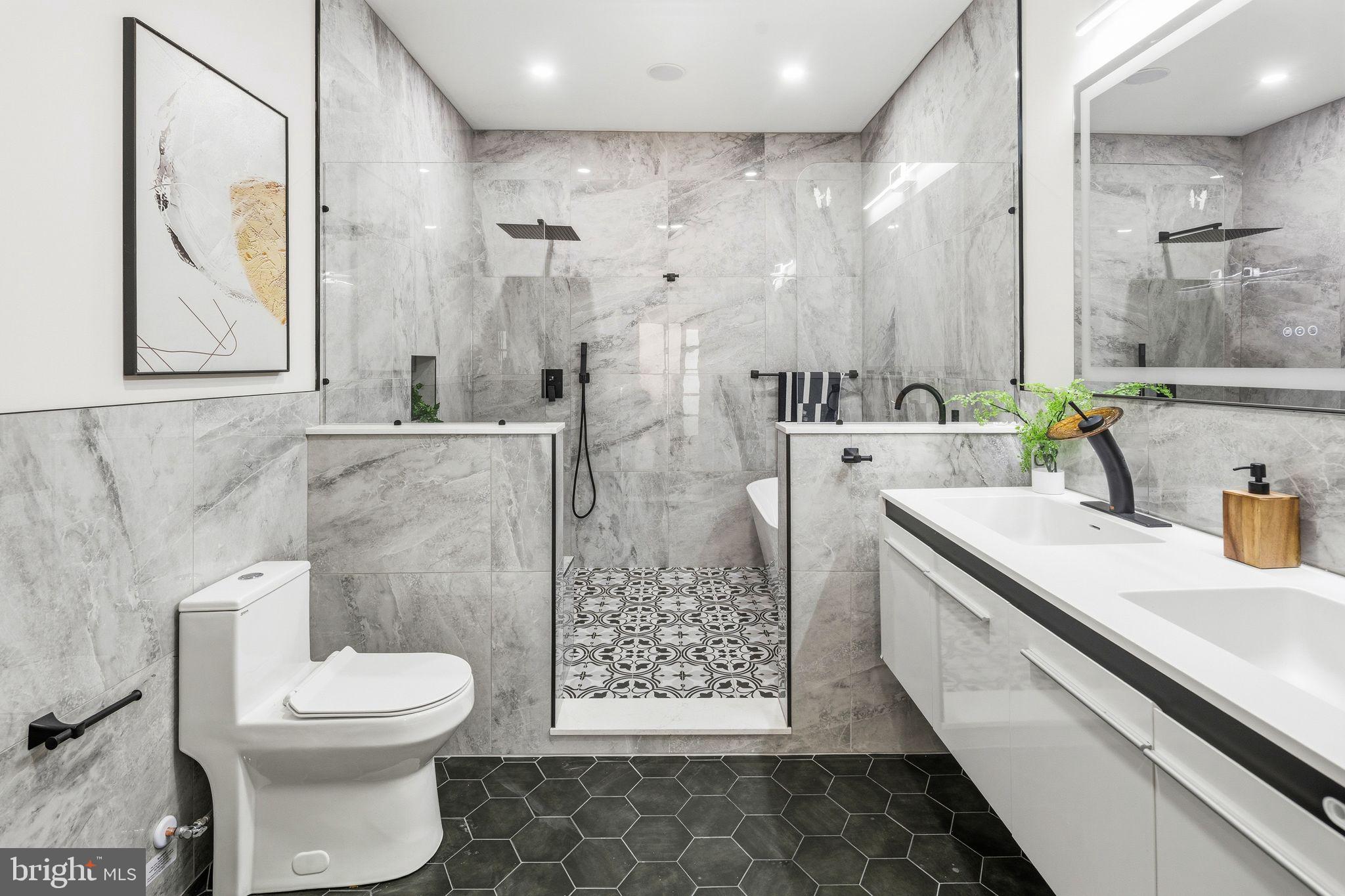 1731 Reed Street Philadelphia, PA 19146 - Photo 18 of 42 a bathroom with a sink a toilet and a large mirror