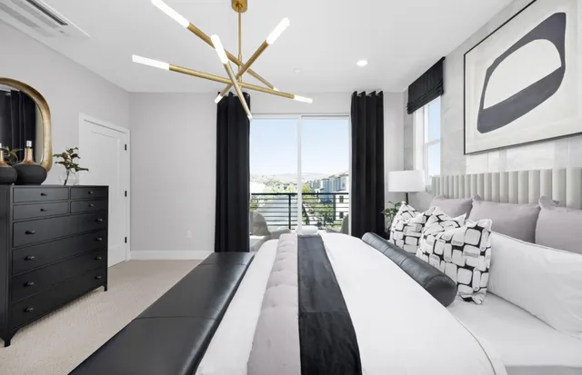 a spacious bedroom with a large bed and a chandelier