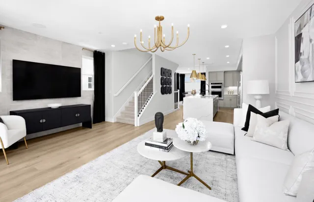 a living room with furniture a flat screen tv and kitchen view