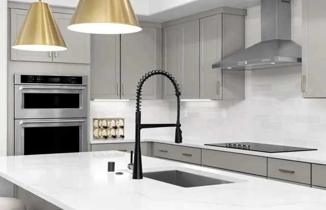 a kitchen with stainless steel appliances kitchen island granite countertop a stove a sink and a refrigerator