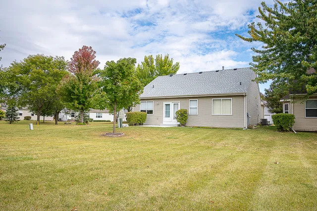a front view of a house with a yard and trees