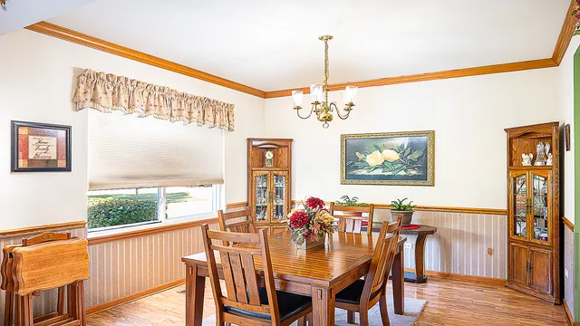 a view of a dining room with furniture a chandelier and wooden floor