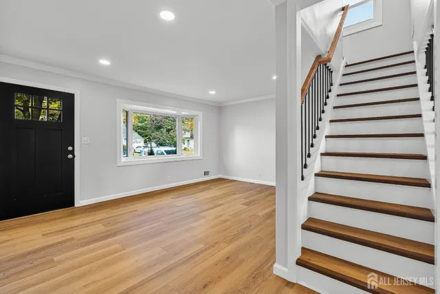 a view of a livingroom with wooden floor and staircase
