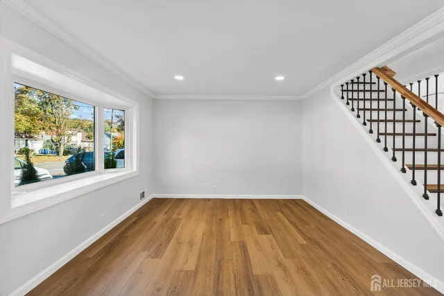 a view of a room with wooden floor and iron stairs