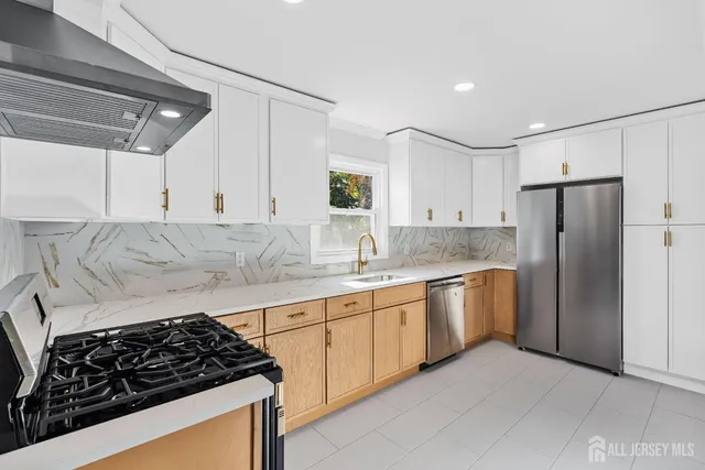 a kitchen with stainless steel appliances granite countertop a sink stove and refrigerator