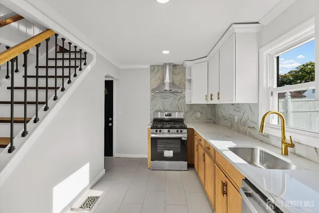 a kitchen with granite countertop a stove a sink and a refrigerator