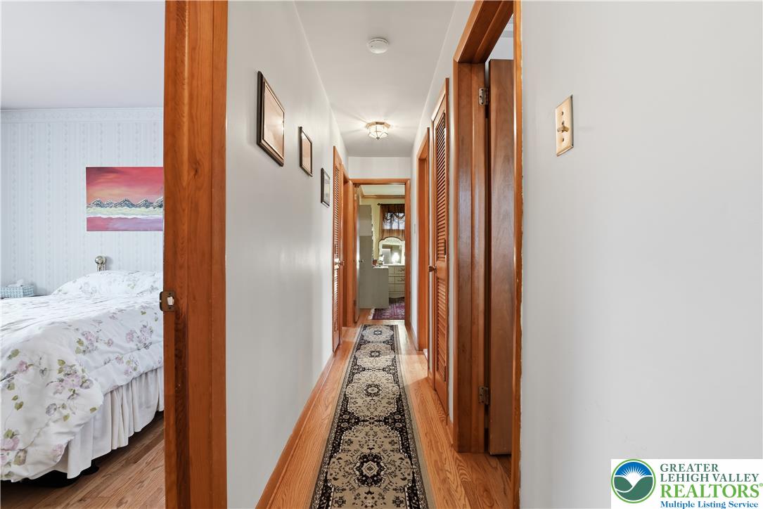 3303 Barklay Road Whitehall, PA 18052 - Photo 21 of 39 A well-maintained hallway with warm wooden trim connects various rooms, leading to a visible bathroom vanity.