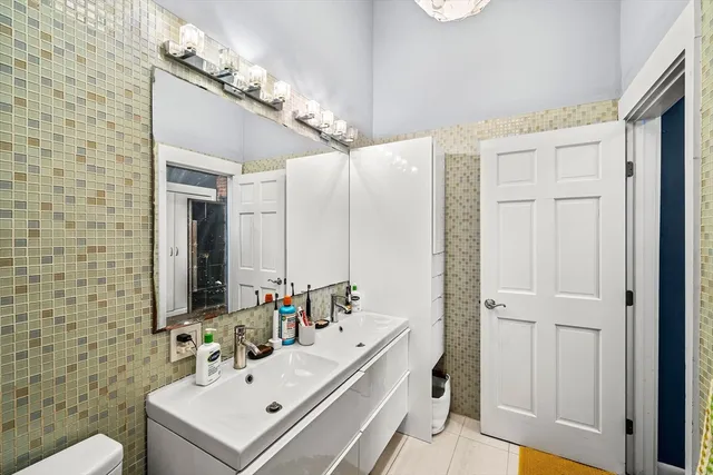 a bathroom with a sink a toilet a mirror and shower