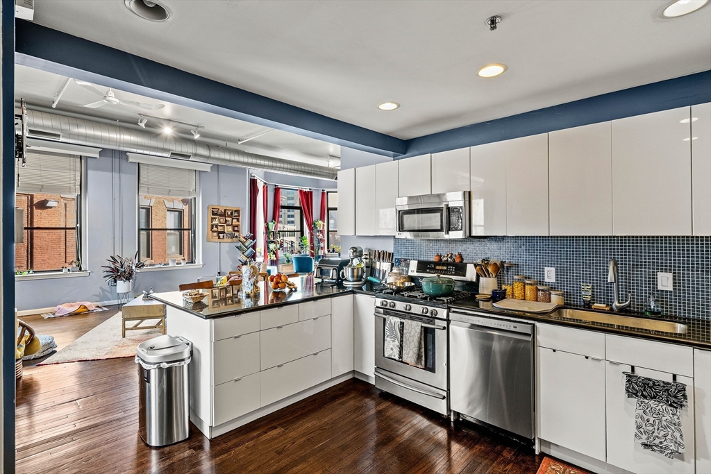 70 Exchange Street, Unit 206 Lynn, MA 01901 - Photo 8 of 40 a kitchen with a sink cabinets and wooden floor