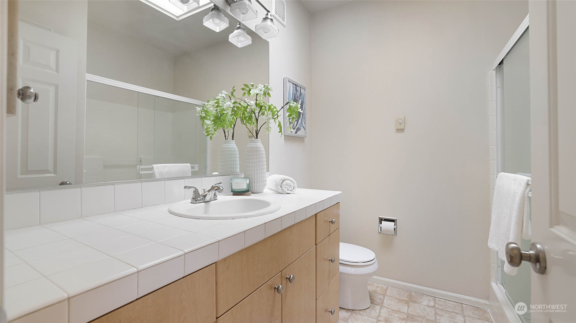 217 South 49th Street, Unit B Renton, WA 98055 - Photo 8 of 16 a bathroom with a granite countertop sink a toilet and a mirror