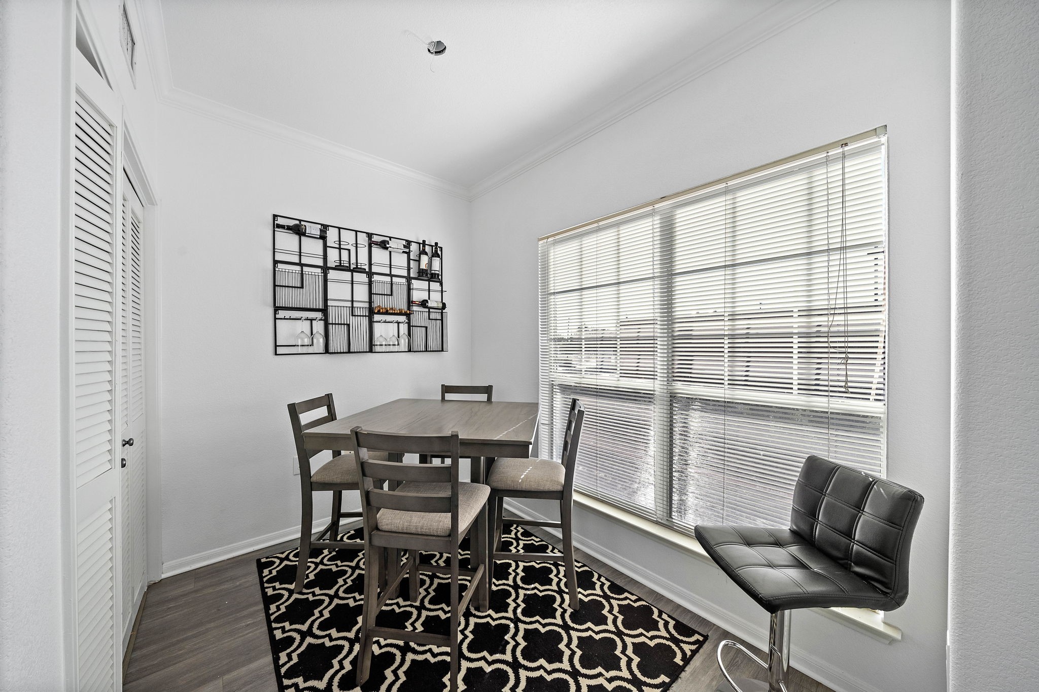 9200 Westheimer Road, Unit 203 Houston, TX 77063 - Photo 3 of 10 This photo shows a bright dining area and large windows with blinds providing ample natural light. The space feels open and inviting.