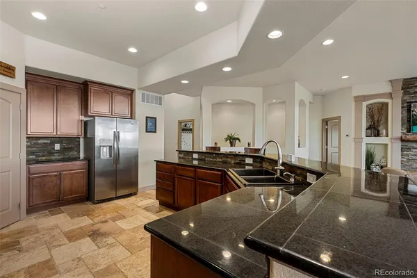 a kitchen with stainless steel appliances granite countertop wooden cabinets a stove a sink and a oven