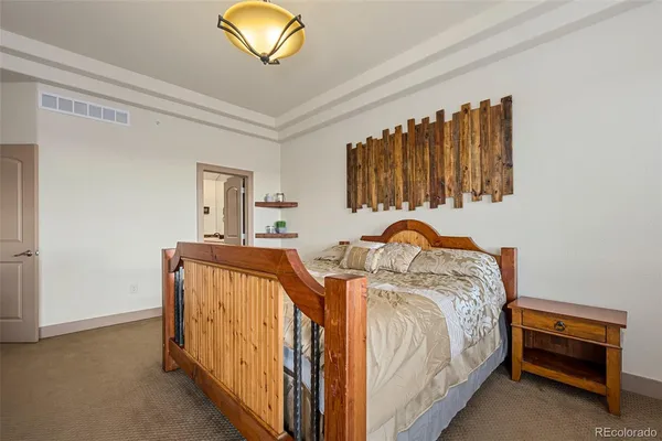 a bedroom with a bed and a flat tv screen on dresser