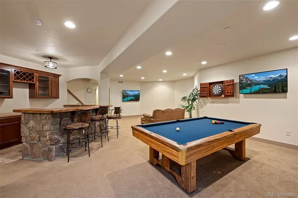 a living room with pool table and a flat screen tv