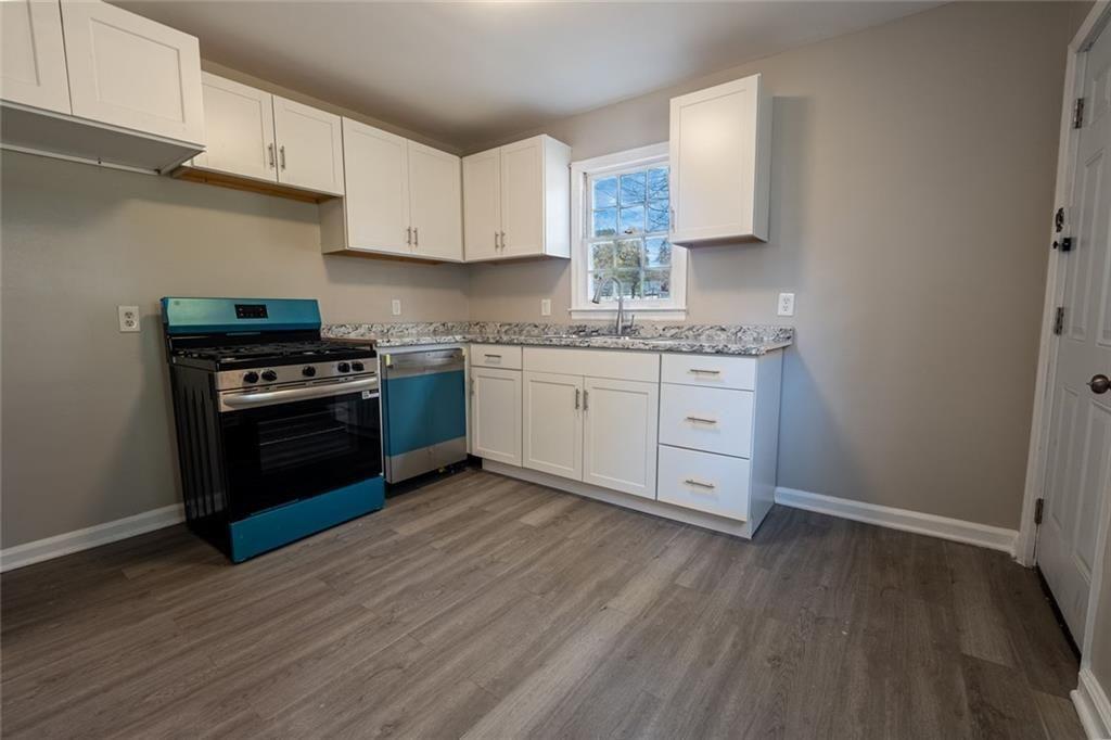 3122 Semmes Street Atlanta, GA 30344 - Photo 24 of 33 a kitchen with granite countertop a stove a sink and a refrigerator