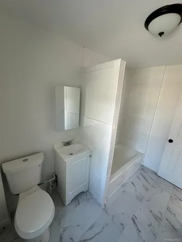 a white toilet sitting next to a bathroom sink