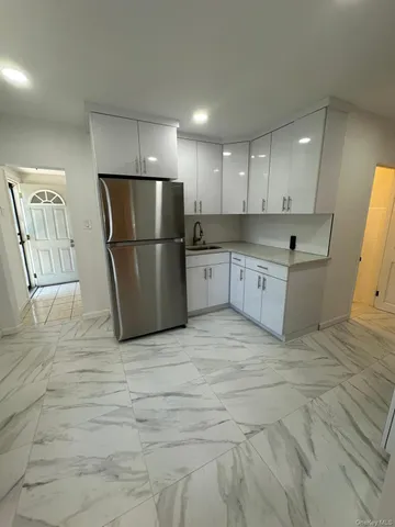 a large kitchen with a refrigerator a sink dishwasher a oven and a large island with wooden floor