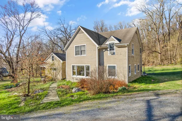 a view of a yard in front of a house with a large tree