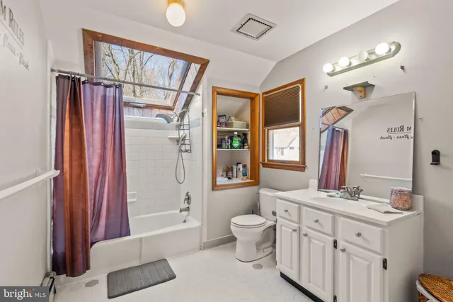 a bathroom with a shower curtain and a window