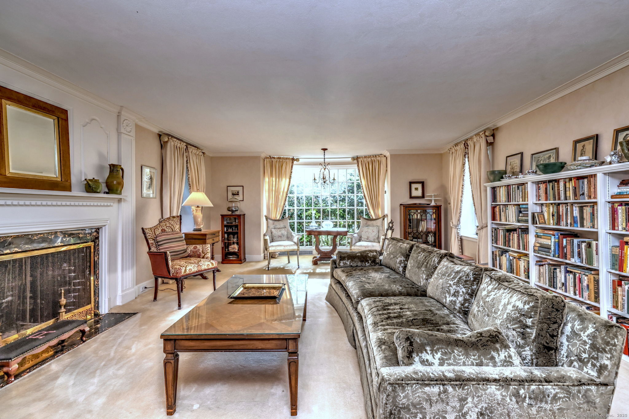 4 Brook Road Woodbridge, CT 06525 - Photo 10 of 40 a living room with furniture a bookshelf and a fireplace