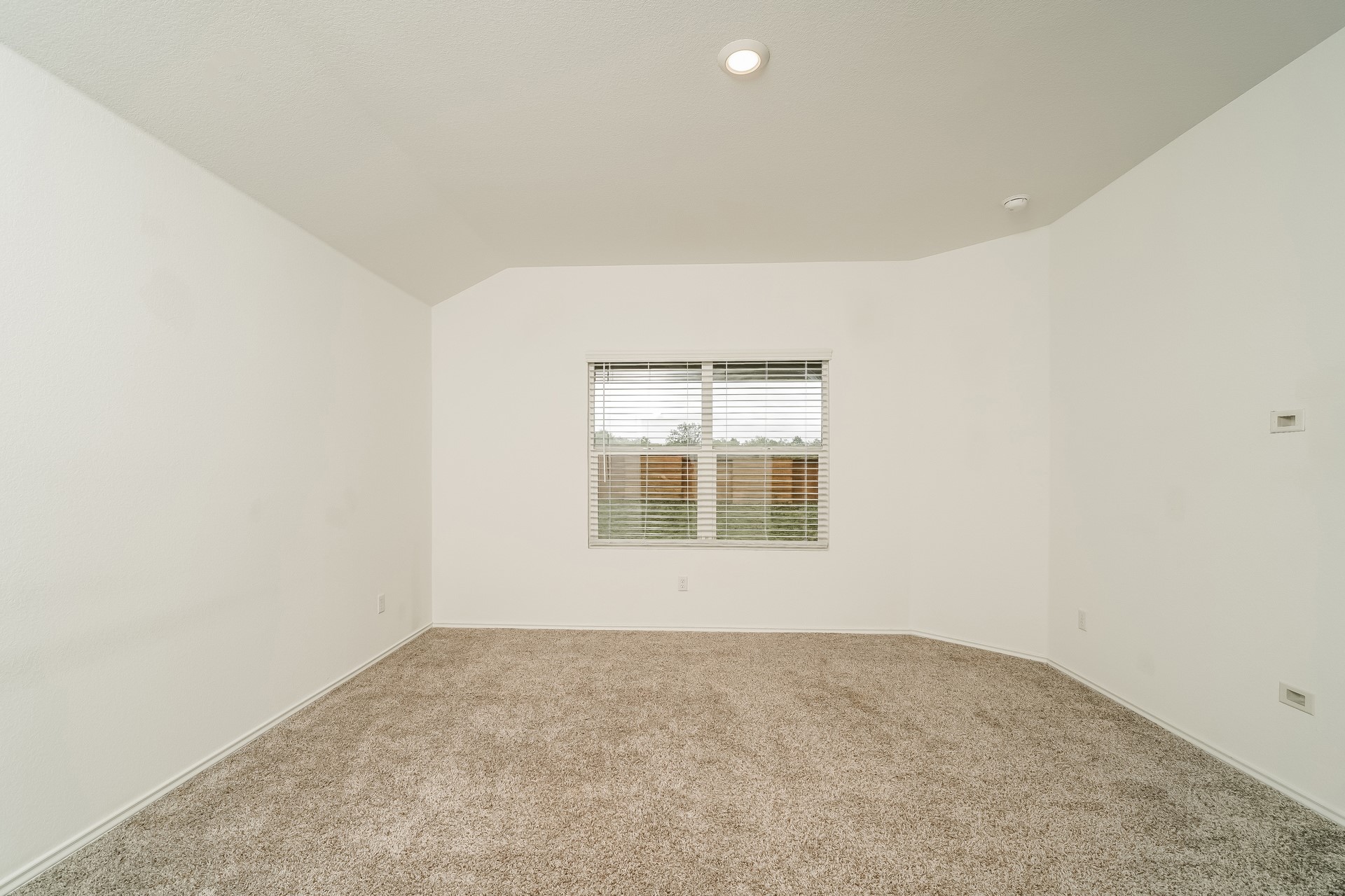 341 Madrid Kyle, TX 78640 - Photo 13 of 27 A well-proportioned bedroom with neutral carpet and a window offering natural light.