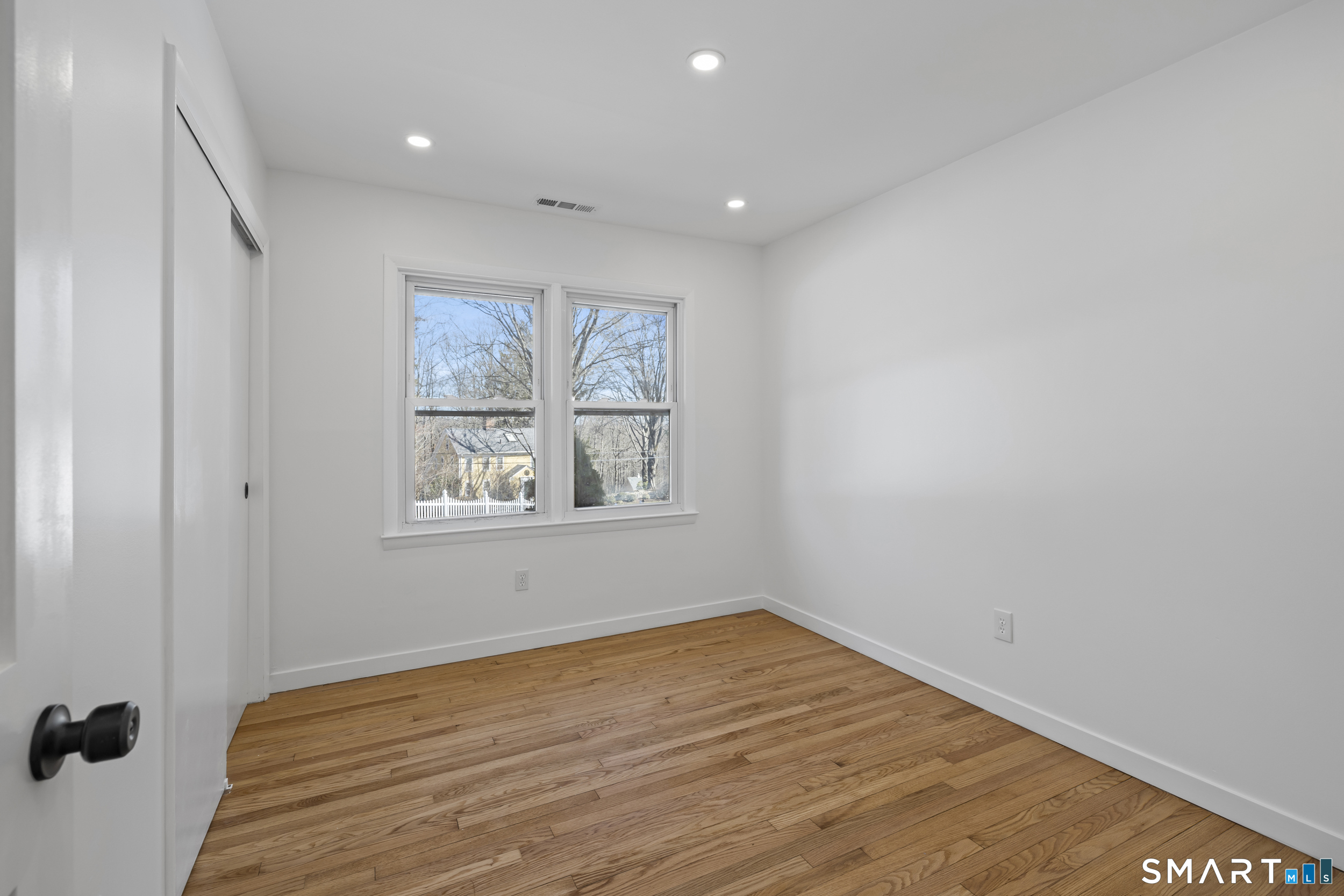 115 Wheeler Road Monroe, CT 06468 - Photo 10 of 18 a view of an empty room with wooden floor and a window