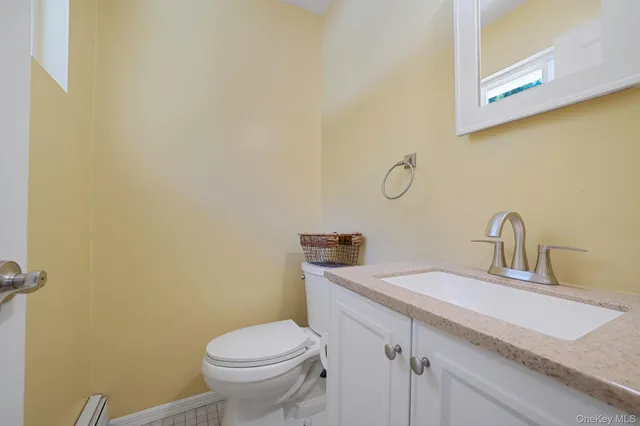 a bathroom with a granite countertop toilet sink and mirror