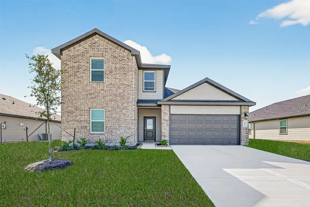 a front view of a house with a yard and garage
