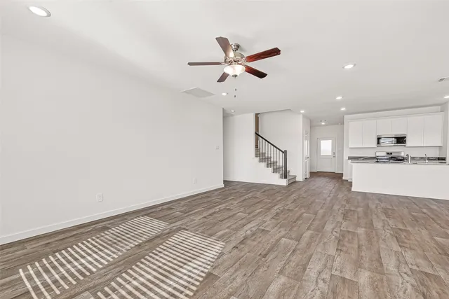 a view of a kitchen with wooden floor and a ceiling fan