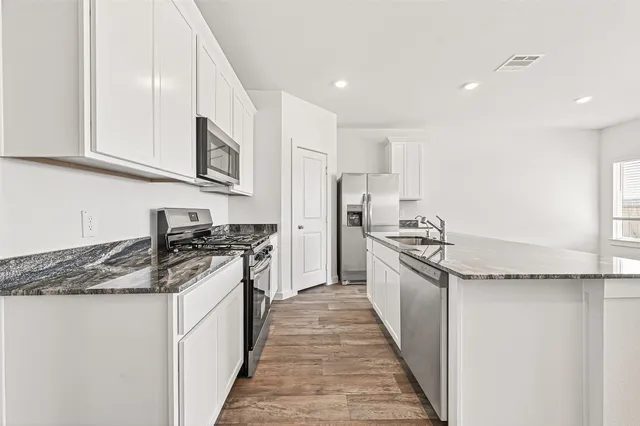 a kitchen with stainless steel appliances granite countertop a sink and cabinets