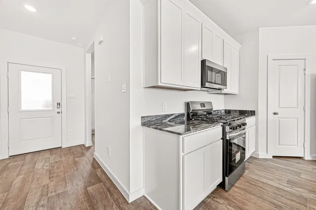 a kitchen with stainless steel appliances granite countertop a stove and a microwave