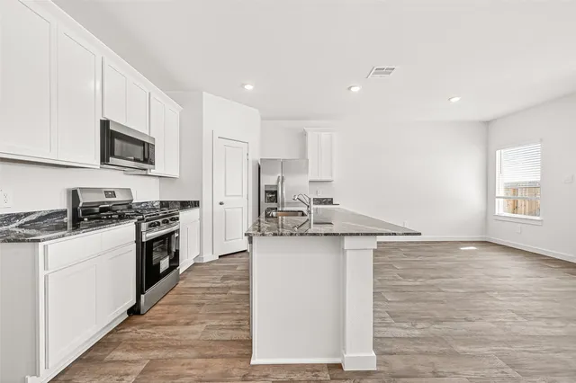 a kitchen with stainless steel appliances granite countertop a sink stove and refrigerator