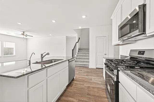 a kitchen with stainless steel appliances granite countertop a sink and a stove