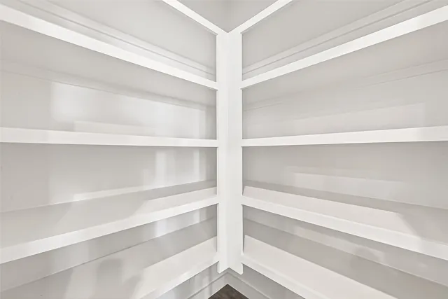 a view of walk in closet with empty racks