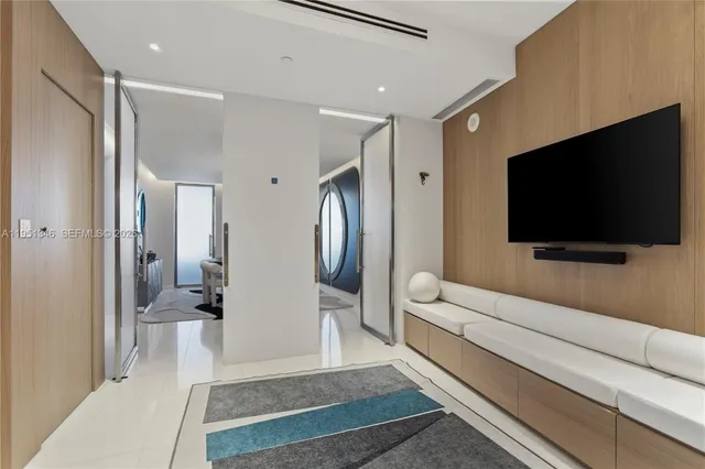 a view of a refrigerator in kitchen and an empty room