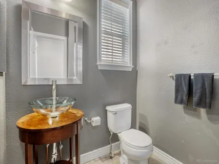 a bathroom with a toilet a sink and mirror