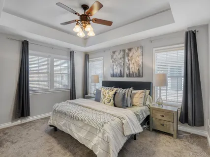 a bedroom with a bed and a chandelier fan