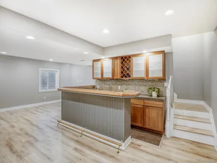 a view of cabinets a counter top space stainless steel appliances wooden floor and a window