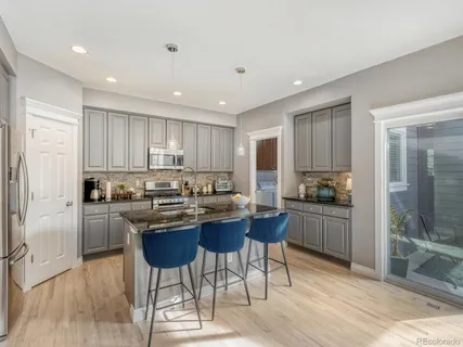 a kitchen with a sink a stove a refrigerator cabinets and dining table