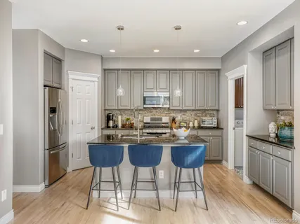 a kitchen with refrigerator and chairs