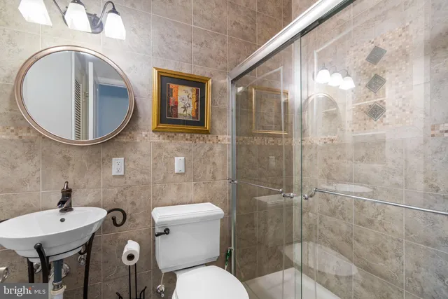 a bathroom with a granite countertop sink a toilet and shower