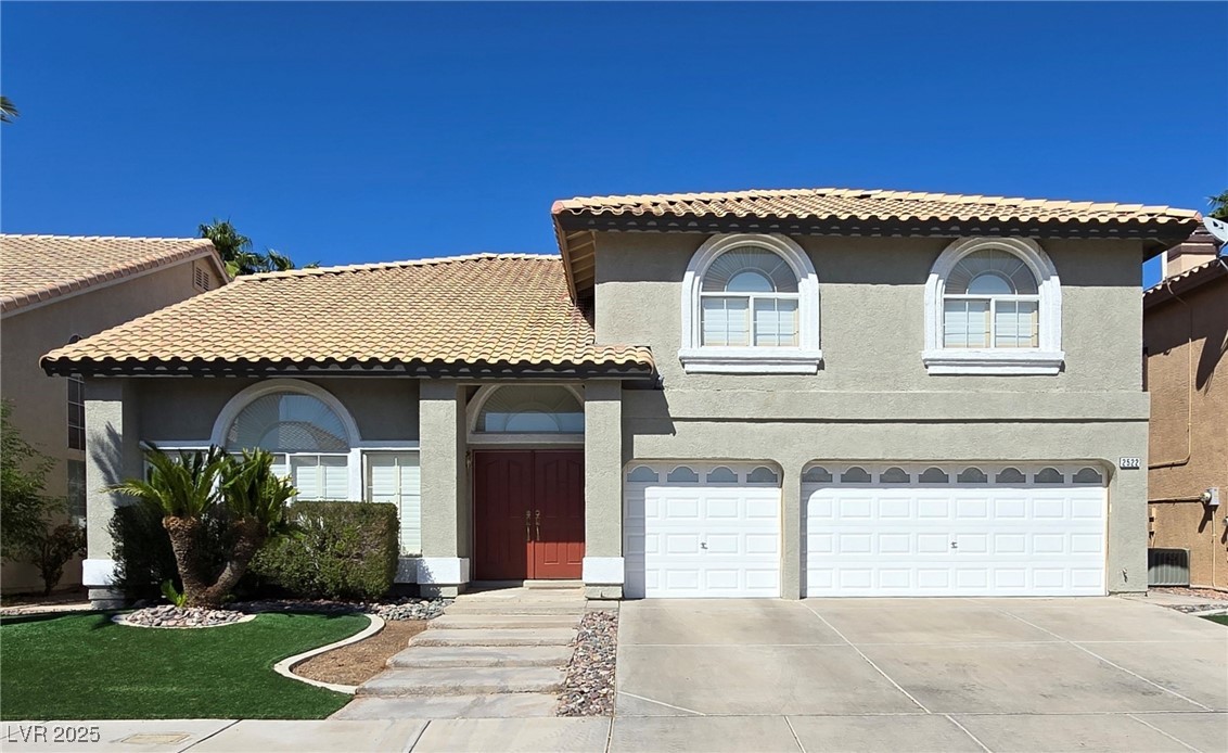 Mediterranean / spanish-style house featuring stucco siding, a tile roof, driveway, and an attached garage