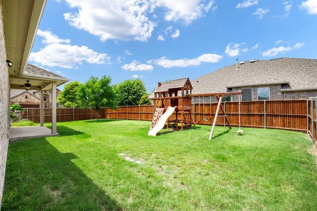 a view of yard with a slide and a tree
