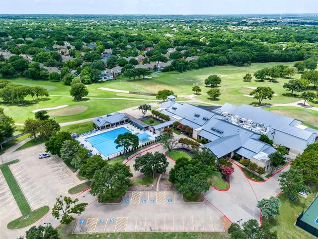 an aerial view of a house with a yard lake and green space