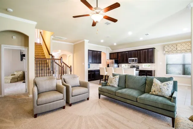 a living room with furniture kitchen view and a chandelier