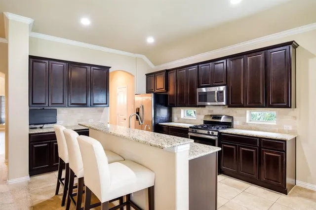 a kitchen with granite countertop wooden cabinets and stainless steel appliances