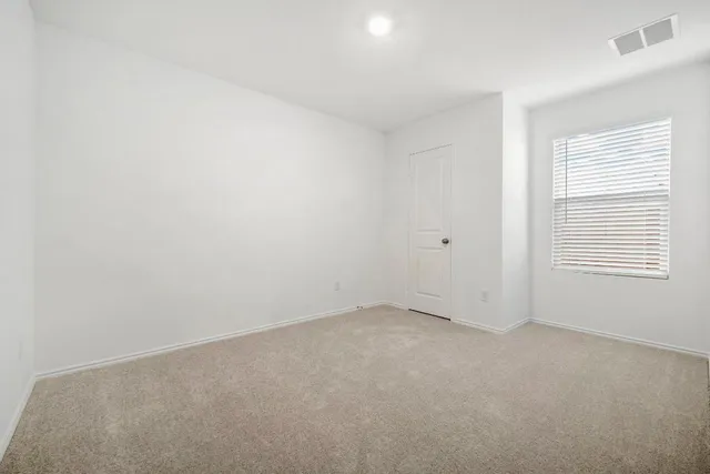 an empty room with windows and book shelf