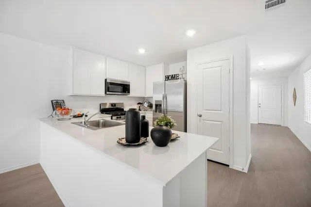a kitchen with stainless steel appliances kitchen island granite countertop a stove a sink and a refrigerator