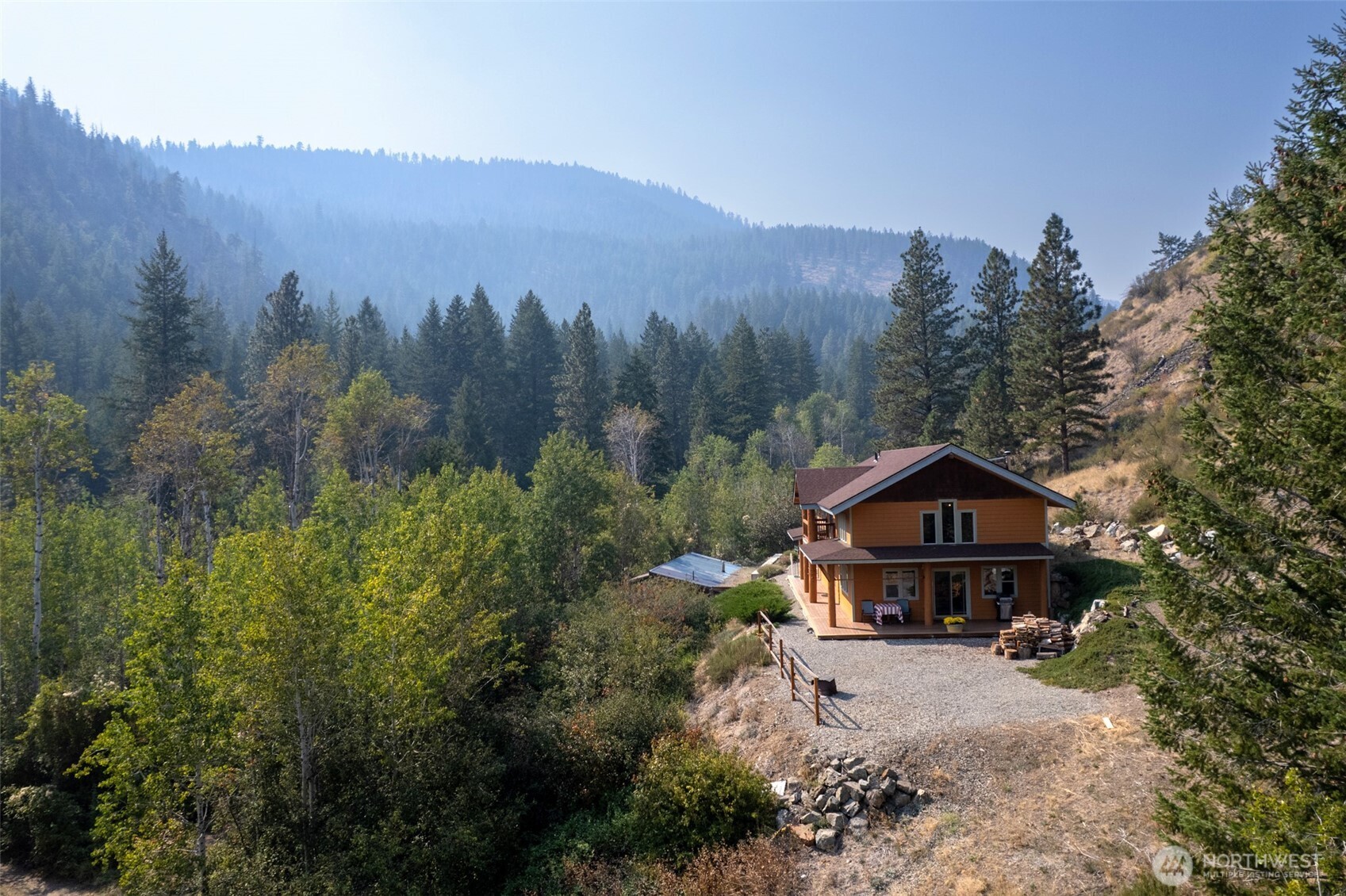 96 Alder Creek Road Twisp, WA 98856 - Photo 4 of 40 a front view of a house with a yard and mountain view in back
