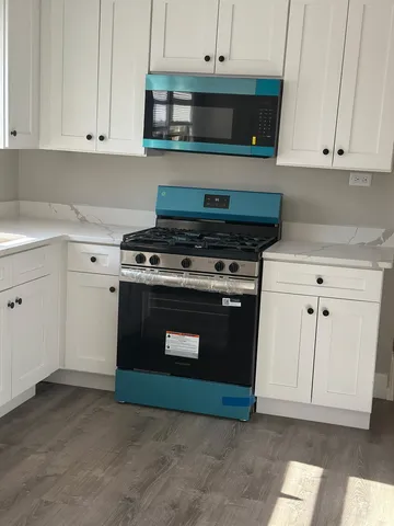 a stove top oven sitting inside of a kitchen